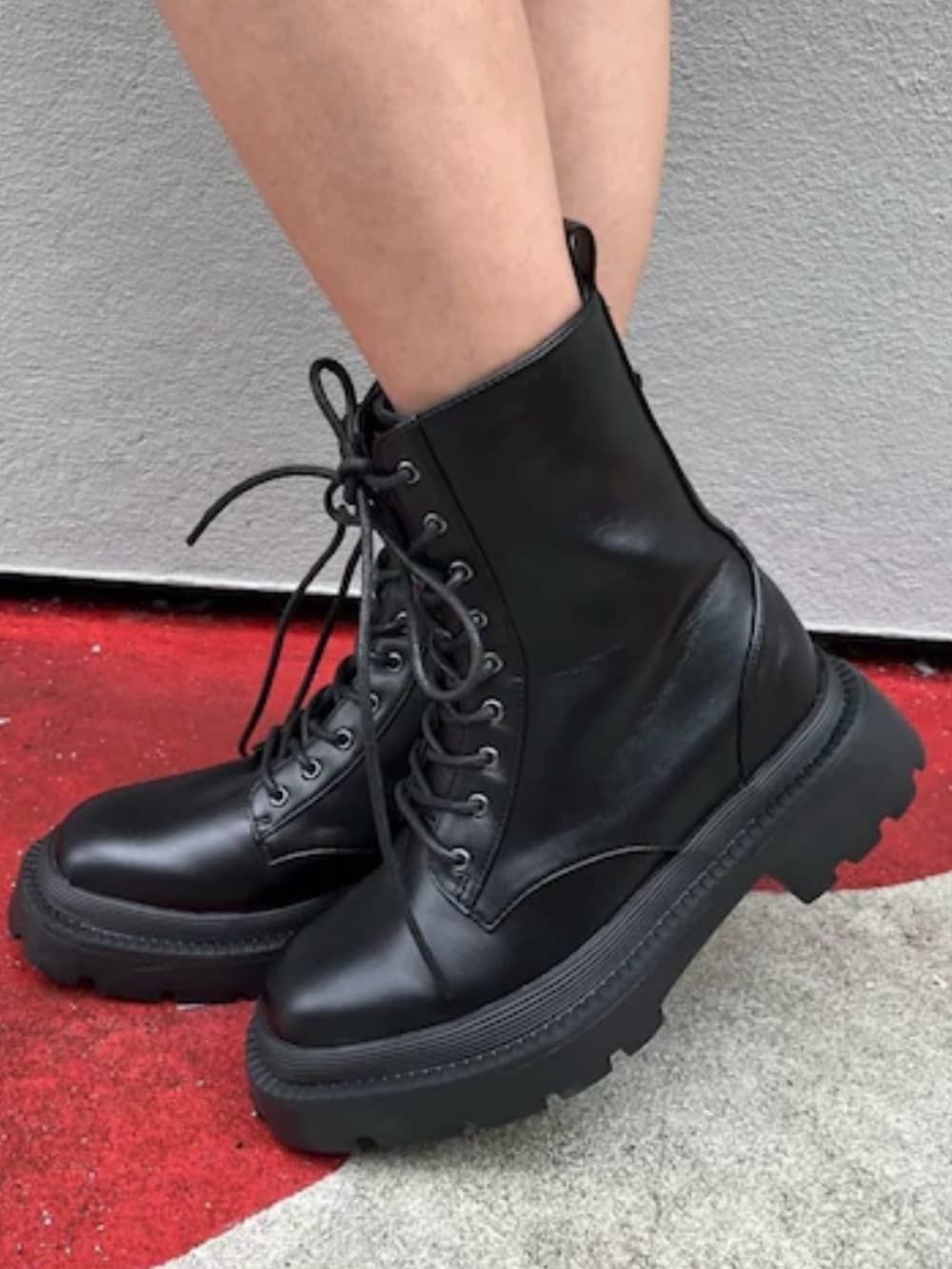 ブラック系のテーラードジャケット、ブラック系のワンピース、ブラック系のブーツを着用したレディースの春コーディネートの7枚目の写真