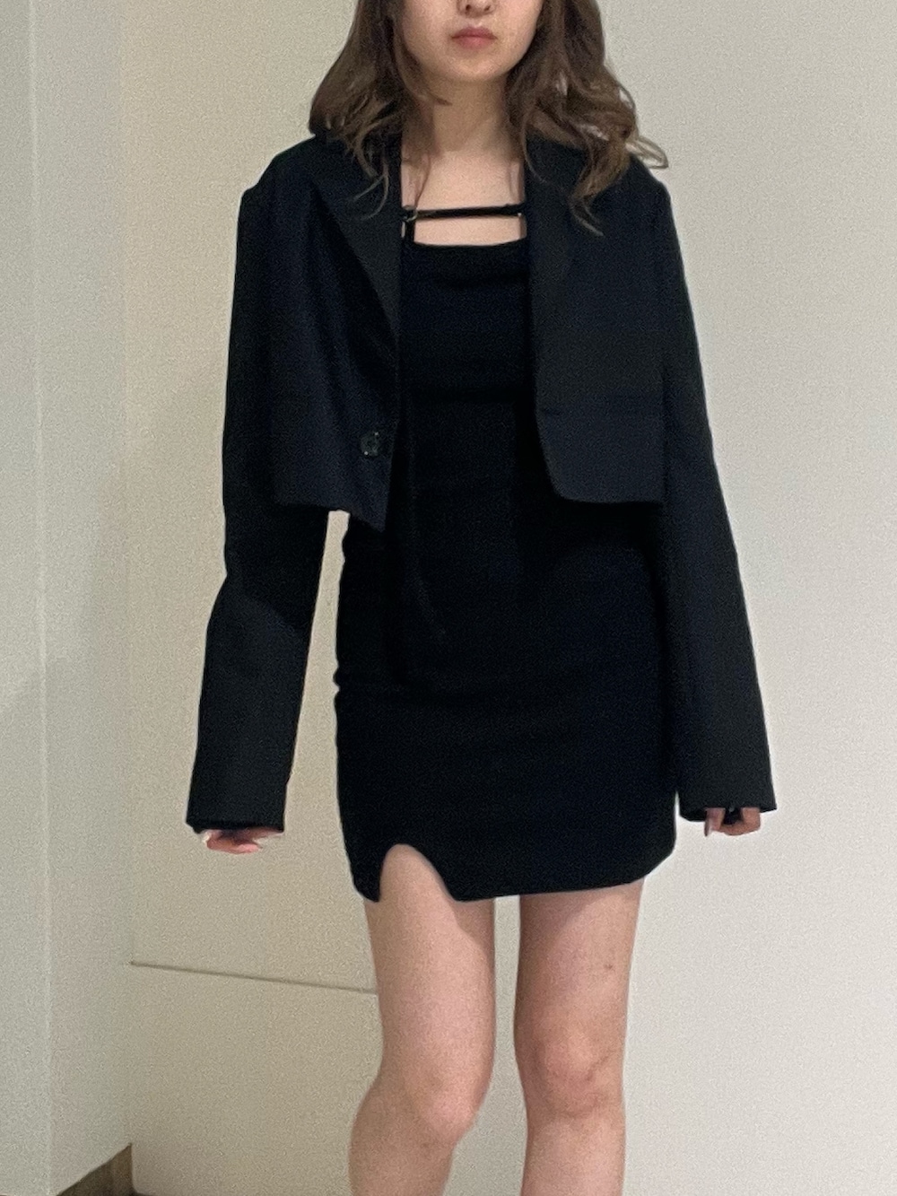 ブラック系のテーラードジャケット、ブラック系のワンピース、ブラック系のブーツを着用したレディースの春コーディネートの6枚目の写真