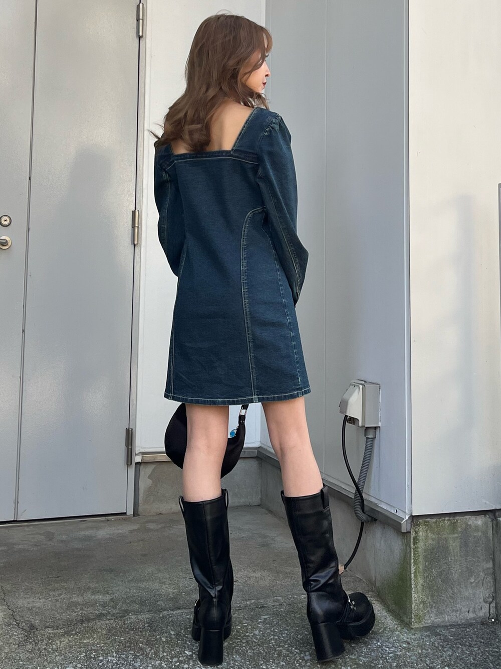 ブルー系のワンピース、ブラック系のブーツ、シルバー系のネックレスを着用したレディースの冬コーディネートの3枚目の写真