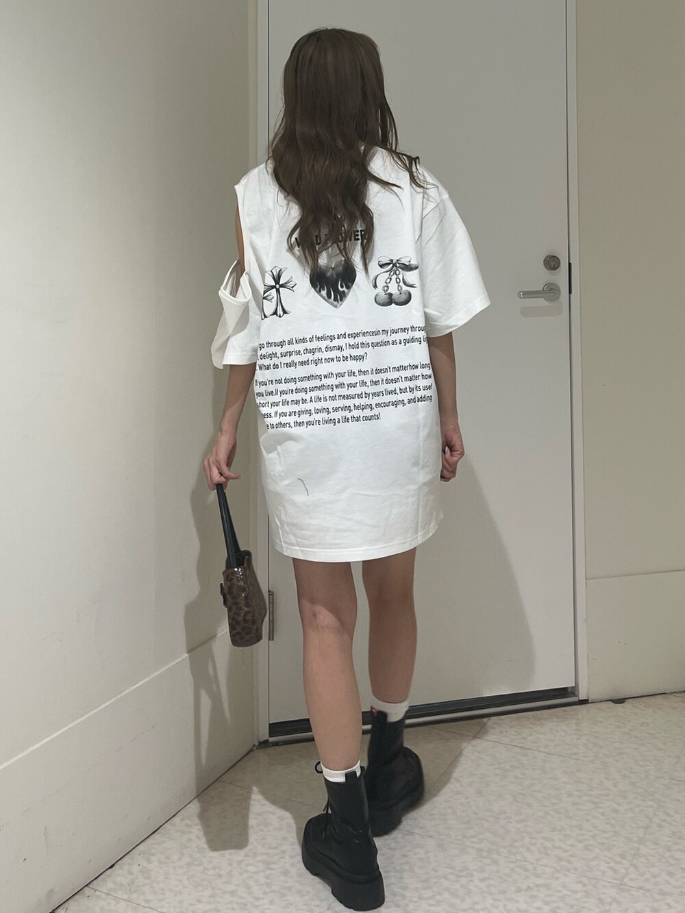 ブラック系のブーツ、ブラウン系のハンドバッグ、ホワイト系のTシャツ/カットソーを着用したレディースの夏コーディネートの3枚目の写真