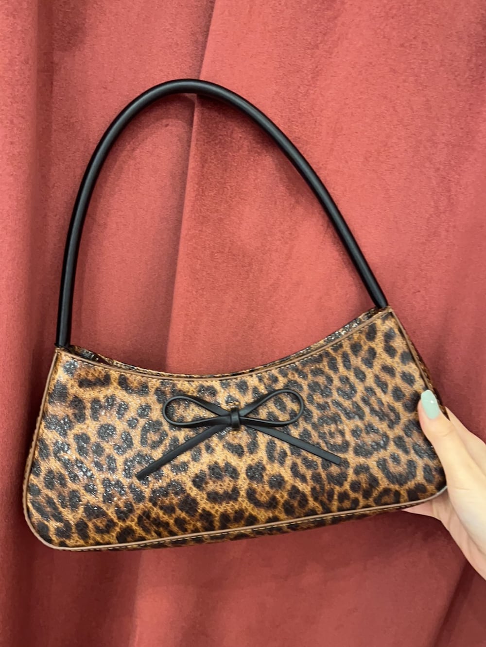 ブラック系のスウェット、ブラック系のスカート、ブラック系のブーツを着用したレディースの春コーディネートの7枚目の写真