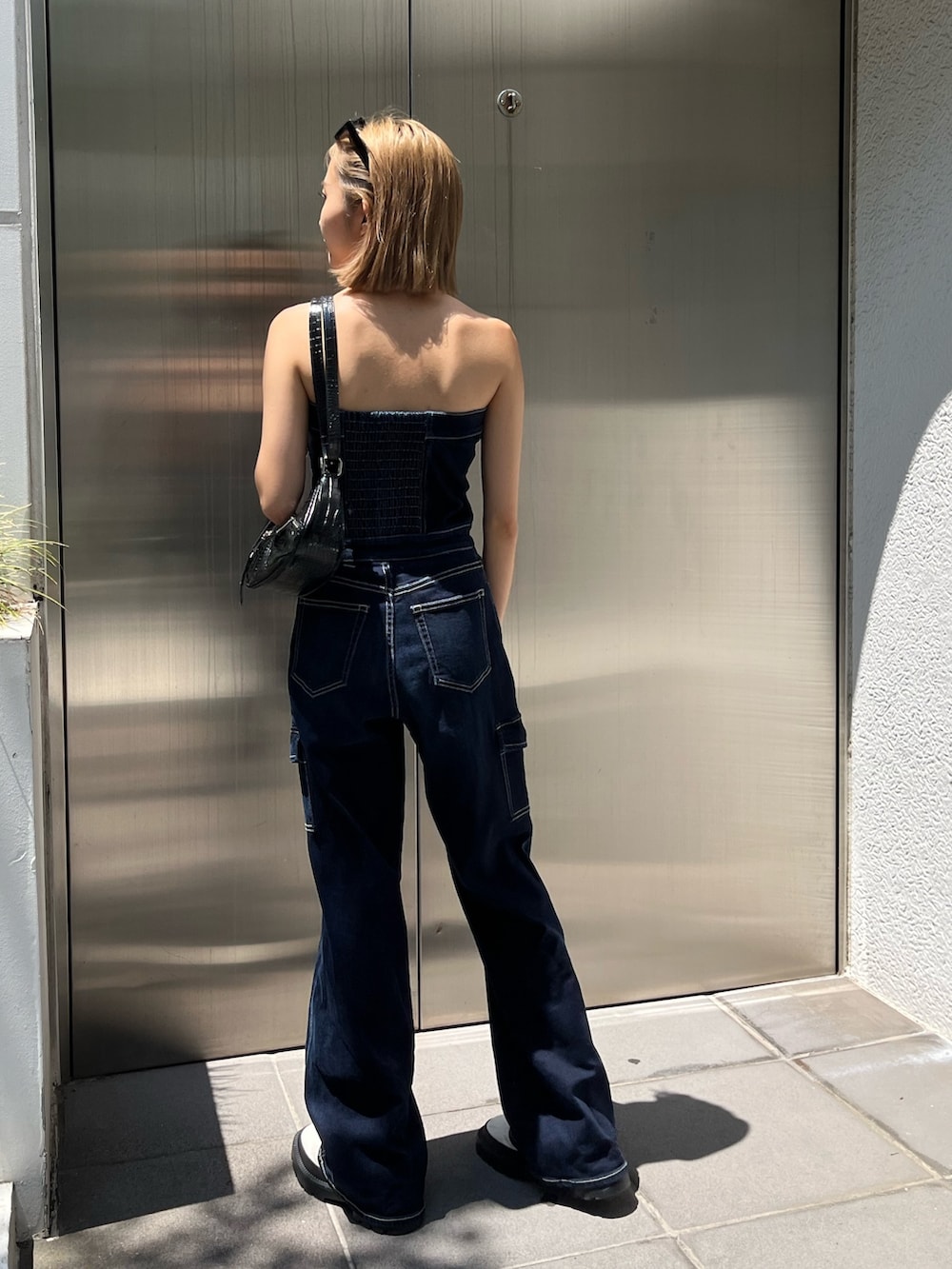 ホワイト系のブーツ、ブルー系のつなぎ/オールインワン、ブラック系のサングラスを着用したレディースの夏コーディネートの3枚目の写真