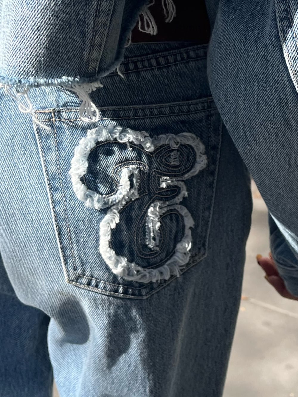 ブルー系のデニムジャケット、ブラック系のハンドバッグ、ブルー系のデニムパンツを着用したレディースの冬コーディネートの4枚目の写真