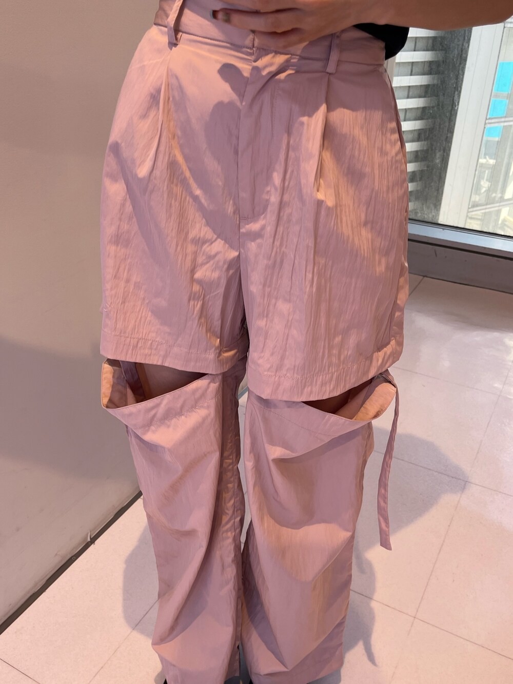 ピンク系のカーゴパンツ、シルバー系のボディバッグ/ウエストポーチ、ブラック系のTシャツ/カットソーを着用したレディースの春コーディネートの6枚目の写真