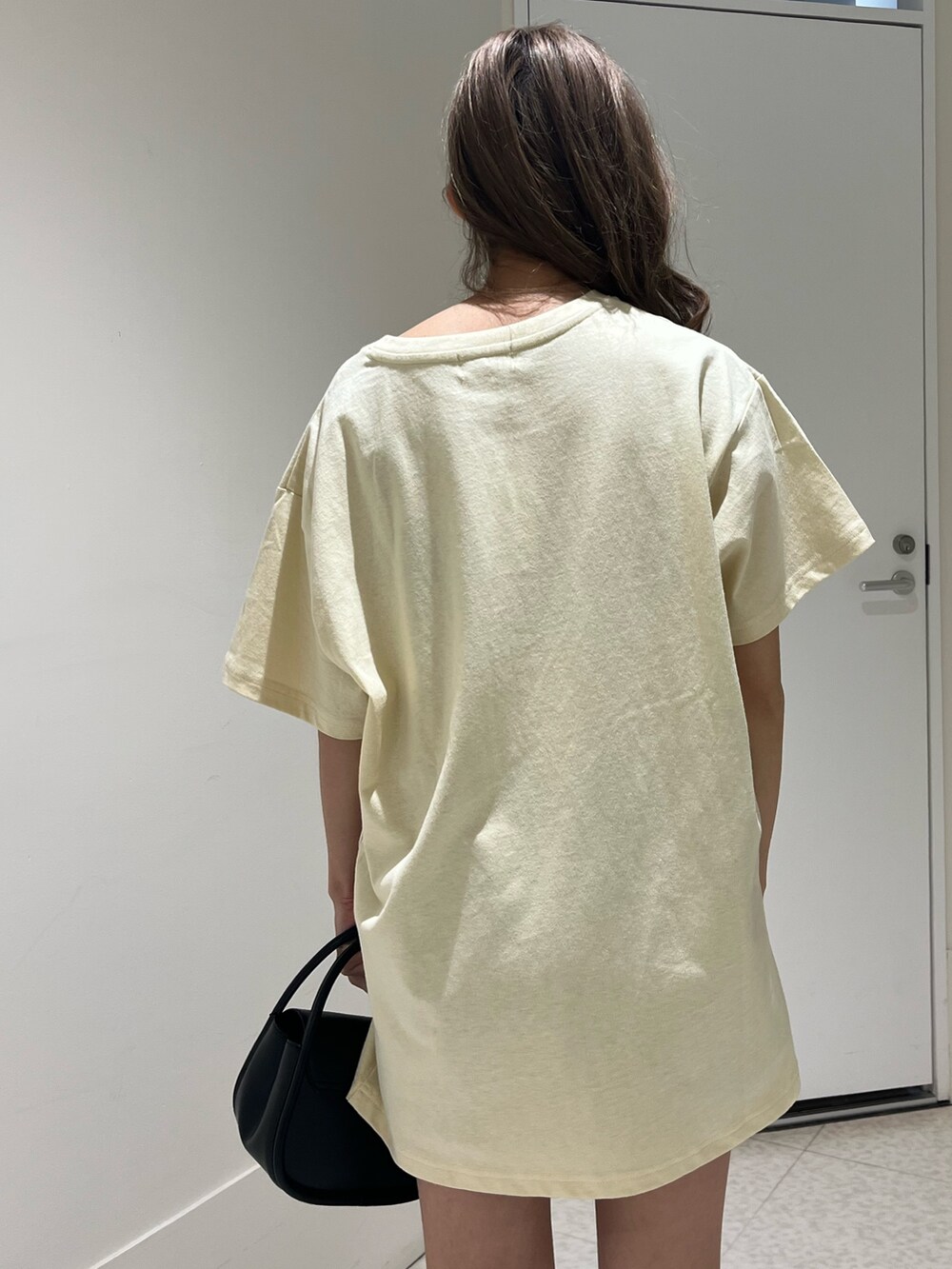 ブルー系のTシャツ/カットソー、ブラック系のハンドバッグ、ブラック系のブーツを着用したレディースの春コーディネートの6枚目の写真