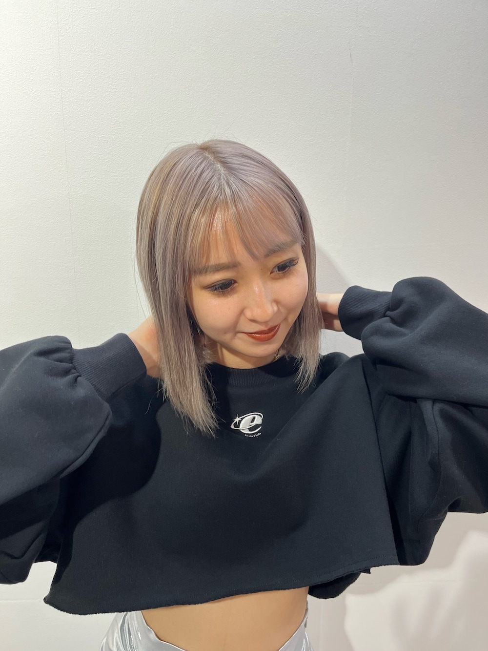 シルバー系のスカート、ホワイト系のスウェットを着用したレディースの秋コーディネートの5枚目の写真