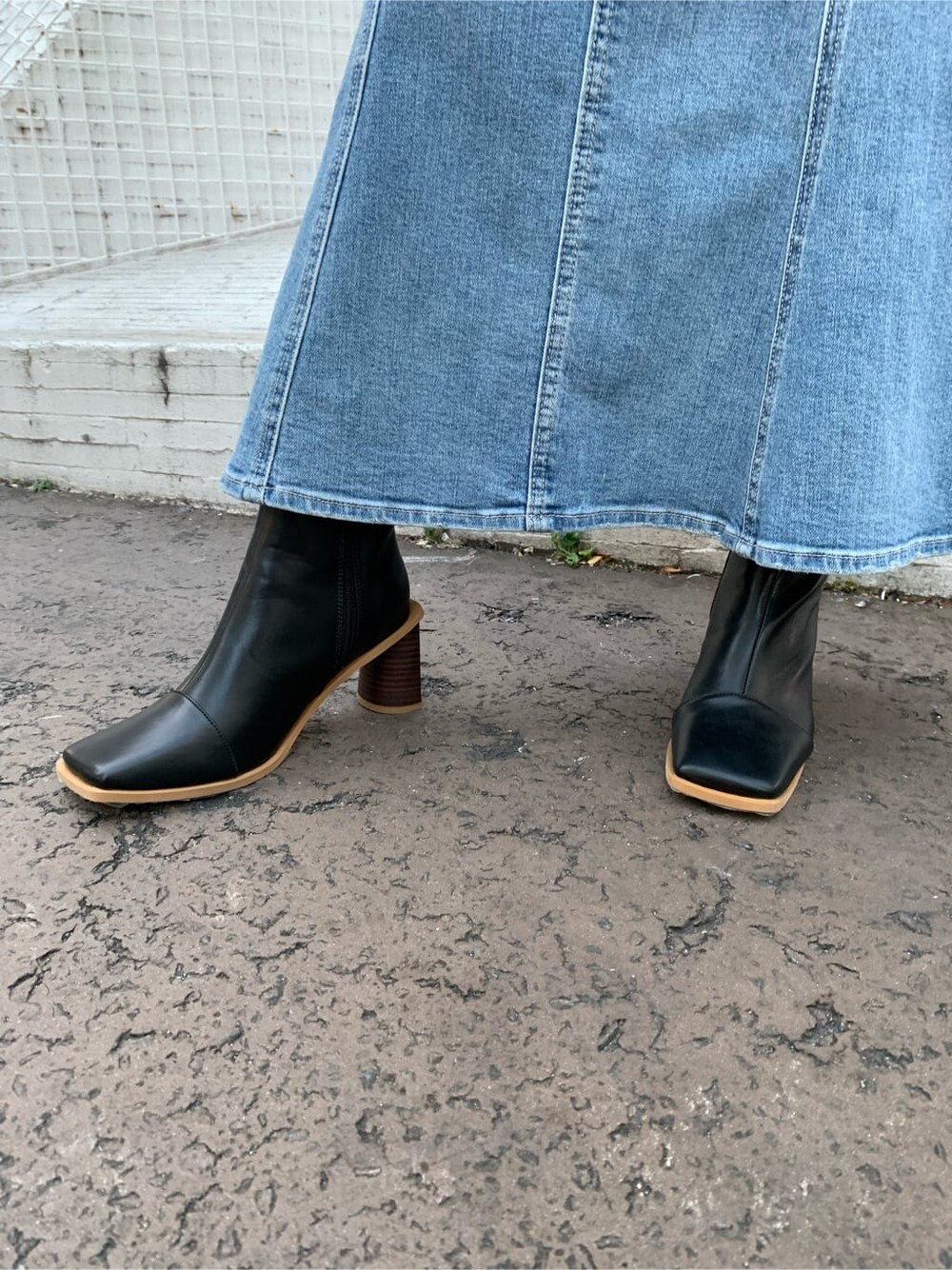 ブラック系のシャツ/ブラウス、ブルー系のデニムスカート、ブラック系のブーツを着用したレディースの冬コーディネートの7枚目の写真