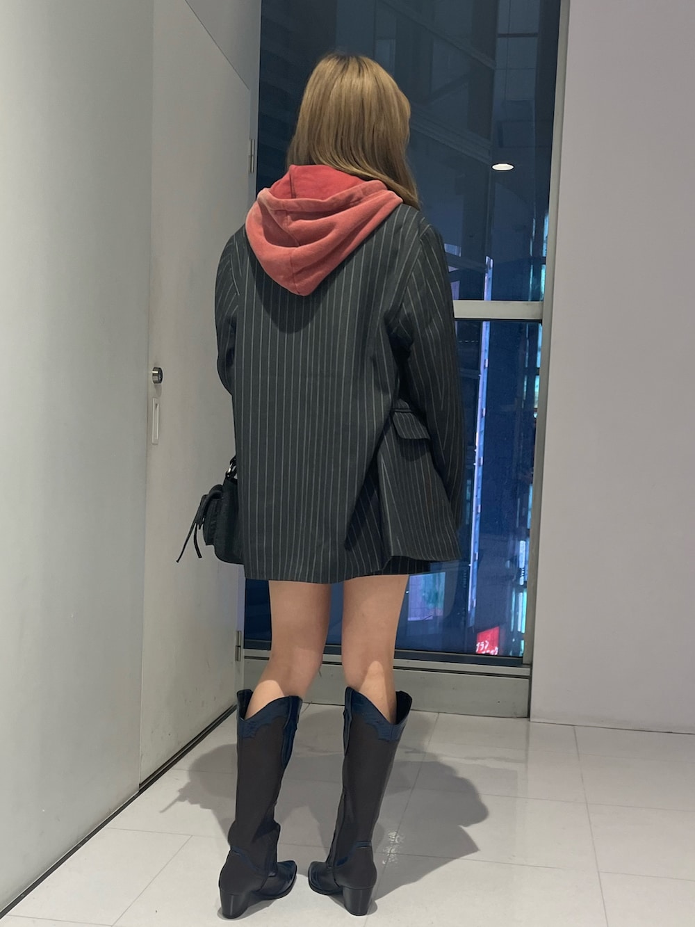 グレー系のテーラードジャケット、グレー系のスカート、レッド系のスウェットを着用したレディースの秋コーディネートの3枚目の写真