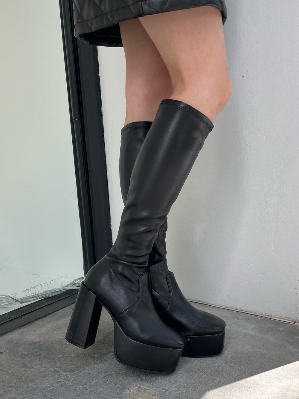 グレー系のスカート、グレー系のTシャツ/カットソー、ホワイト系のブーツを着用したレディースの秋コーディネートの7枚目の写真