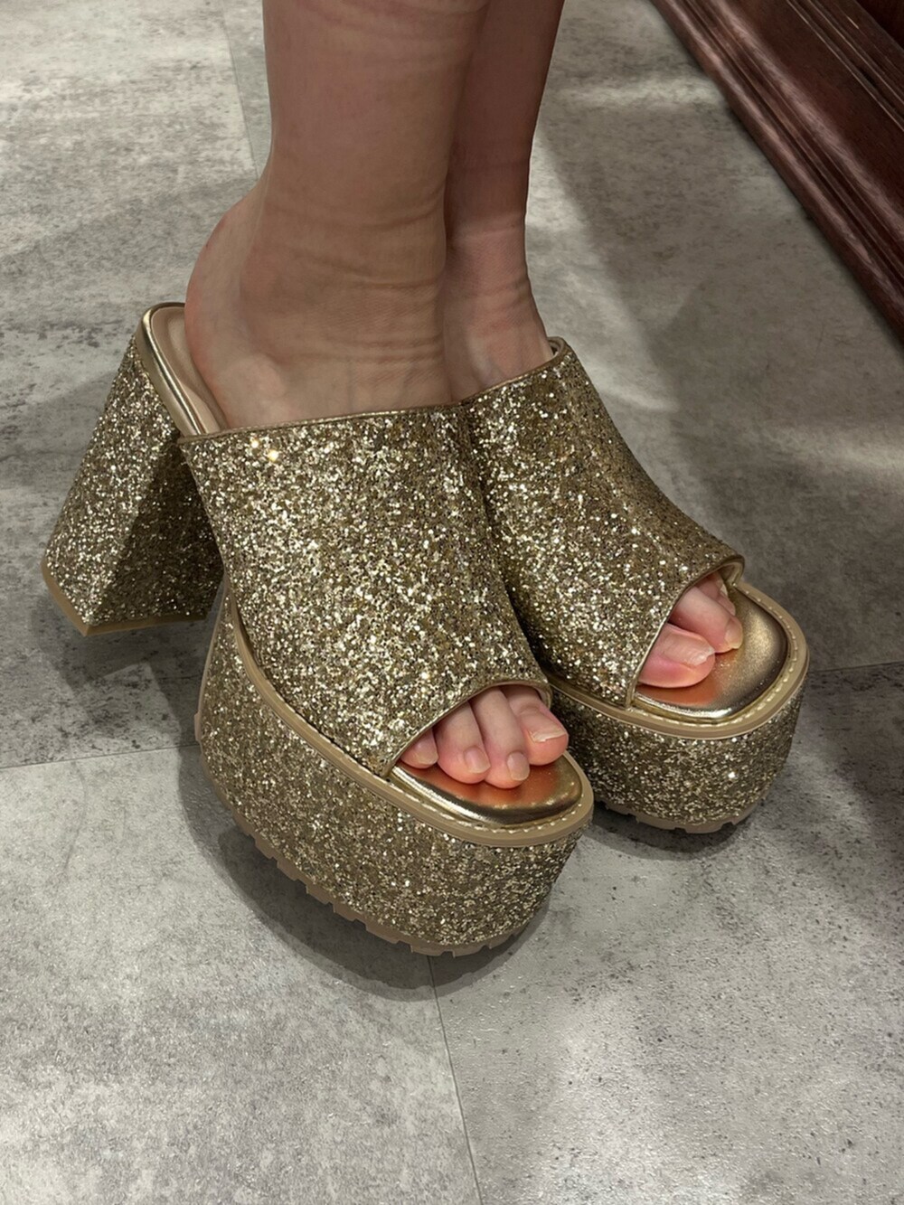 ブラウン系のハンドバッグ、シルバー系のサンダル、ブルー系のデニムパンツを着用したレディースの夏コーディネートの6枚目の写真