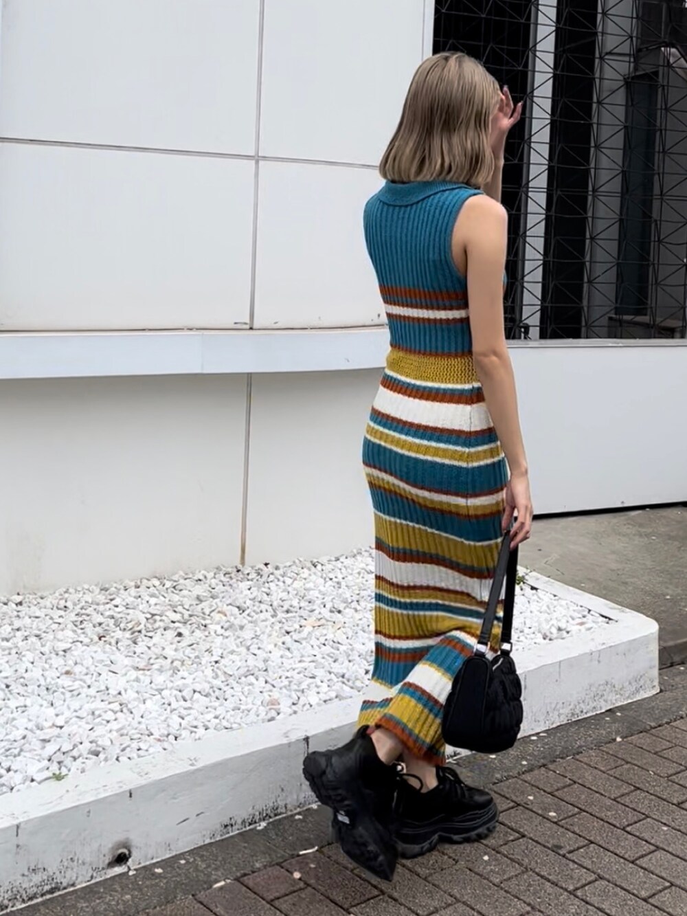 ブラック系のワンピースを着用したレディースの春コーディネートの5枚目の写真