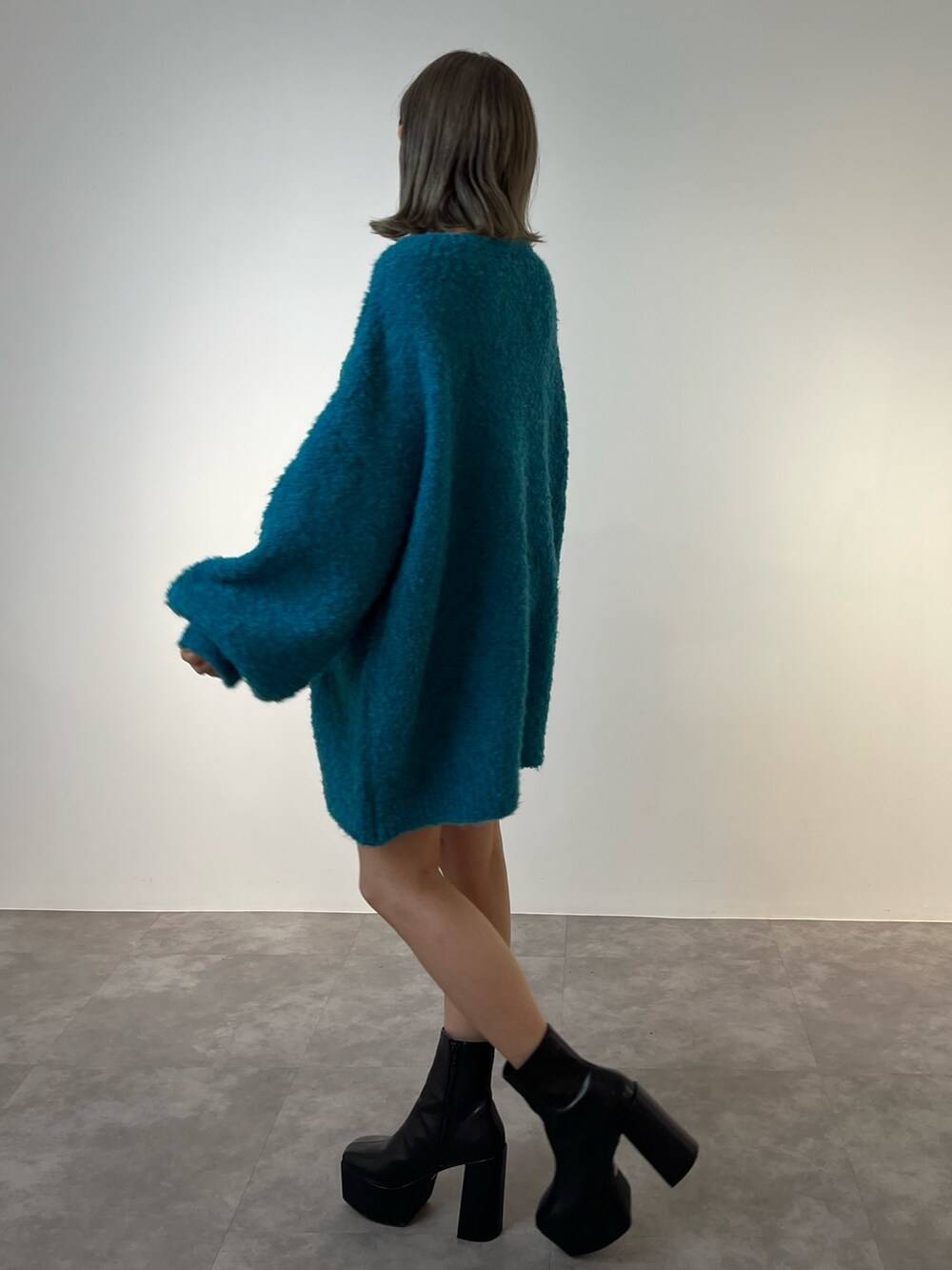 ブルー系のニット/セーター、ブラック系のブーツを着用したレディースの冬コーディネートの4枚目の写真