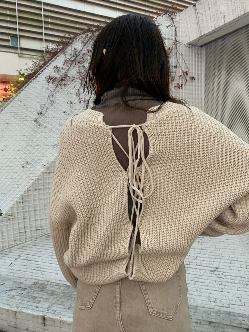 ブラウン系のブーツ、ベージュ系のTシャツ/カットソー、ホワイト系のトレンチコートを着用したレディースの冬コーディネートの5枚目の写真