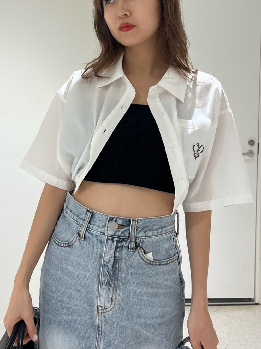 ブラック系のブーツ、ブルー系のデニムパンツ、その他のショルダーバッグを着用したレディースの春コーディネートの4枚目の写真