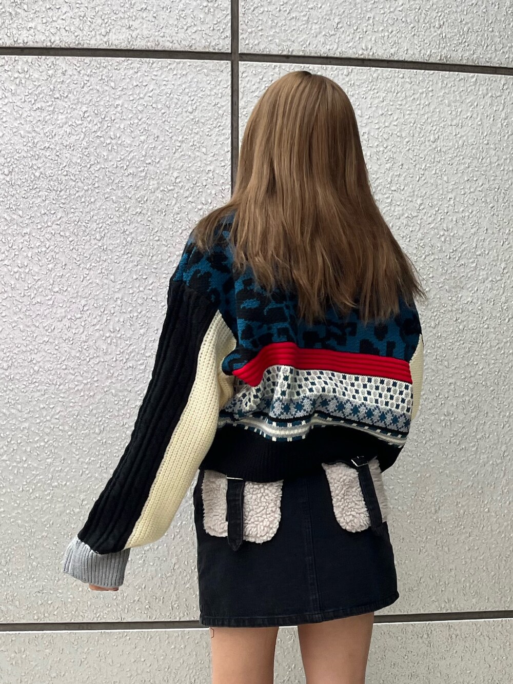 ブラック系のブーツ、ブラック系のデニムスカート、ブルー系のニット/セーターを着用したレディースの秋コーディネートの7枚目の写真