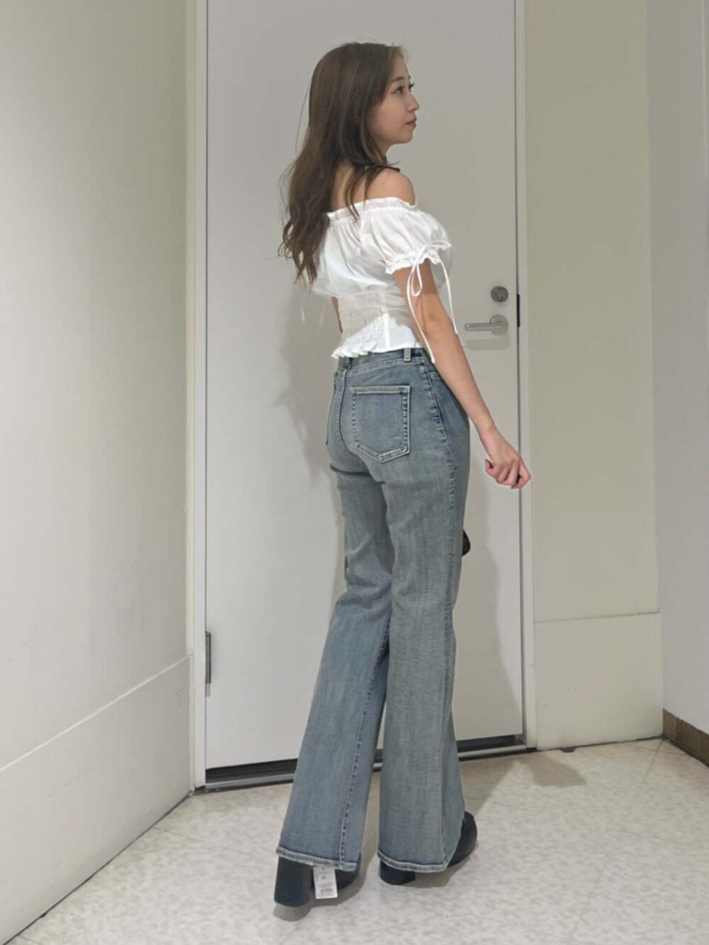 ブラウン系のハンドバッグ、ブラック系のサンダル、ホワイト系のシャツ/ブラウスを着用したレディースの夏コーディネートの4枚目の写真