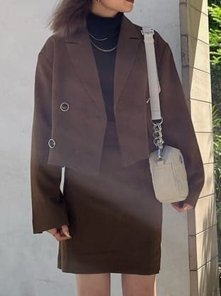 ブラウン系のスカート、ブラック系のニット/セーター、ブラック系のブーツを着用したレディースの秋コーディネートの2枚目の写真