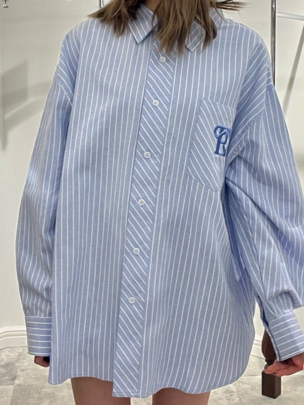 ホワイト系のシャツ/ブラウス、シルバー系のブーツを着用したレディースの春コーディネートの6枚目の写真