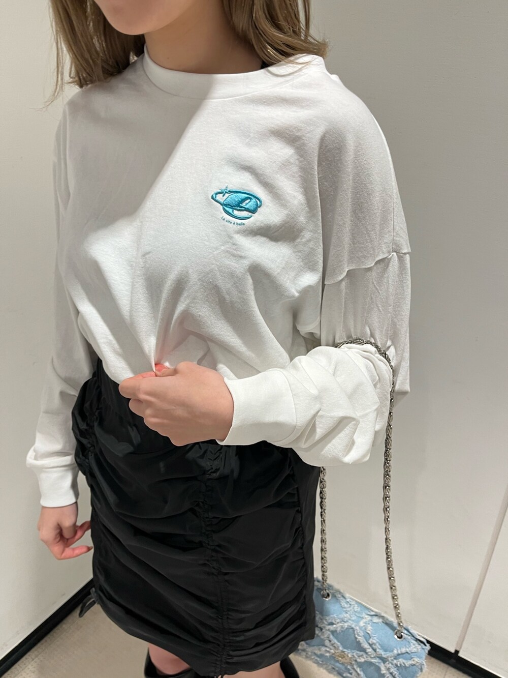ホワイト系のブーツ、ブルー系のショルダーバッグ、ホワイト系のTシャツ/カットソーを着用したレディースの冬コーディネートの8枚目の写真