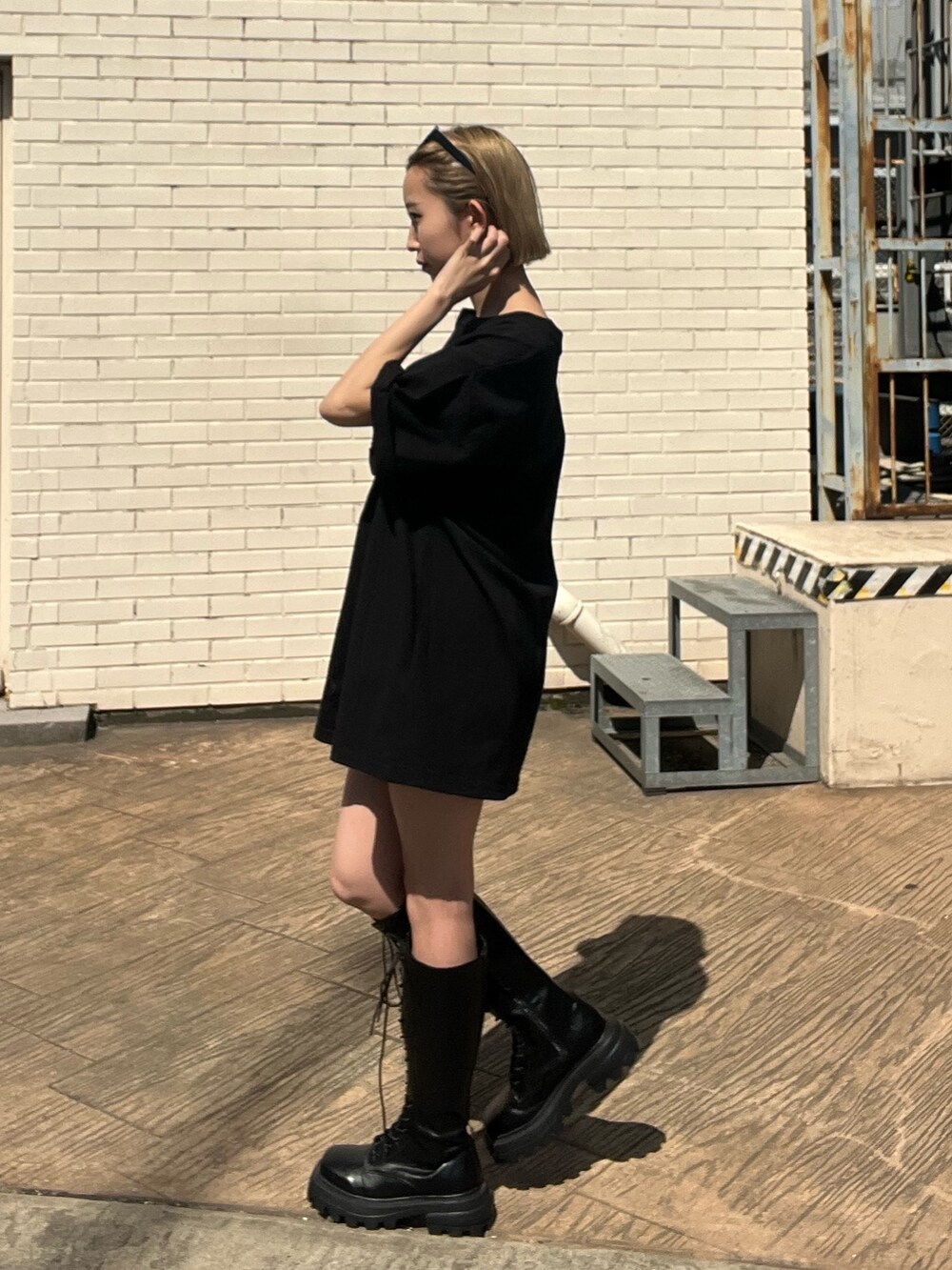 ブラック系のTシャツ/カットソー、ブラック系のブーツ、ブラック系のサングラスを着用したレディースの春コーディネートの2枚目の写真