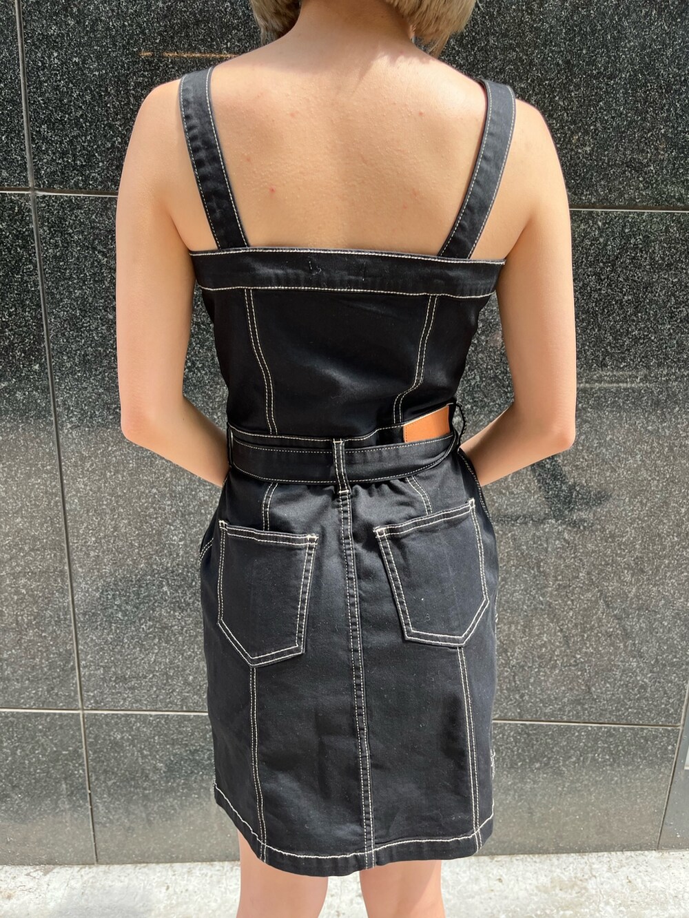 ブラック系のブーツ、ブラック系のジャンパースカートを着用したレディースの春コーディネートの6枚目の写真