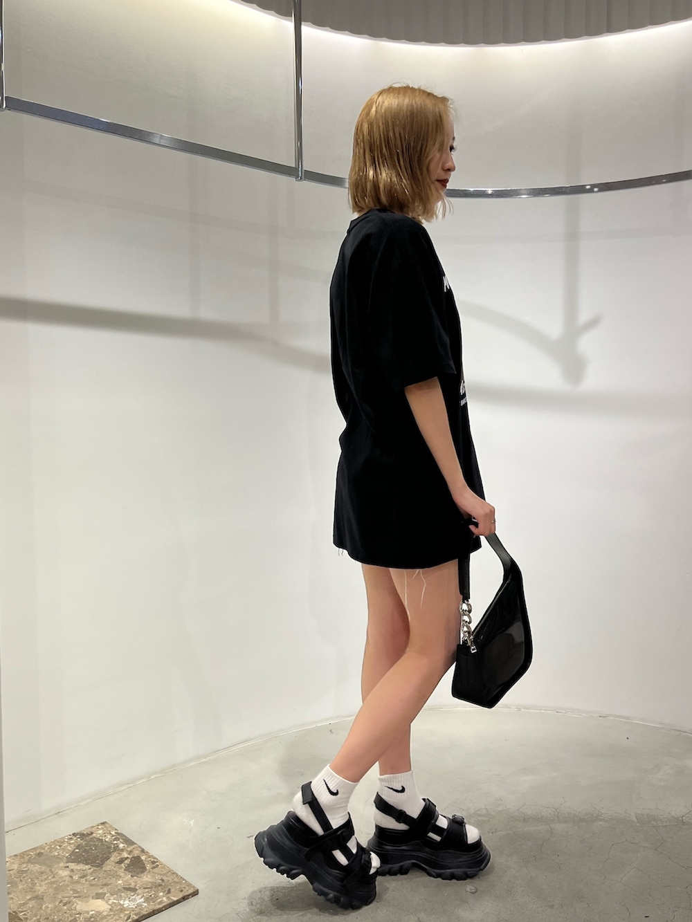 ブラック系のサンダル、ホワイト系のハンドバッグ、ホワイト系のTシャツ/カットソーを着用したレディースの夏コーディネートの3枚目の写真
