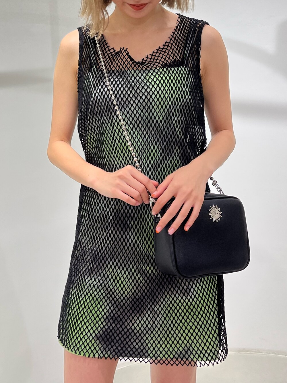 グリーン系のワンピース、ブラック系のサンダル、ブラック系のショルダーバッグを着用したレディースの春コーディネートの9枚目の写真