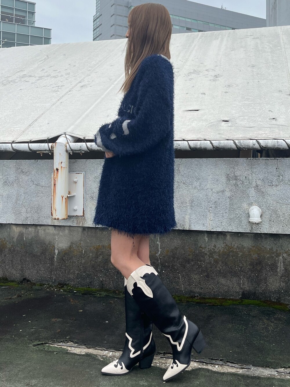 ホワイト系のスカート、ブラウン系のブーツ、ブルー系のニット/セーターを着用したレディースの秋コーディネートの5枚目の写真