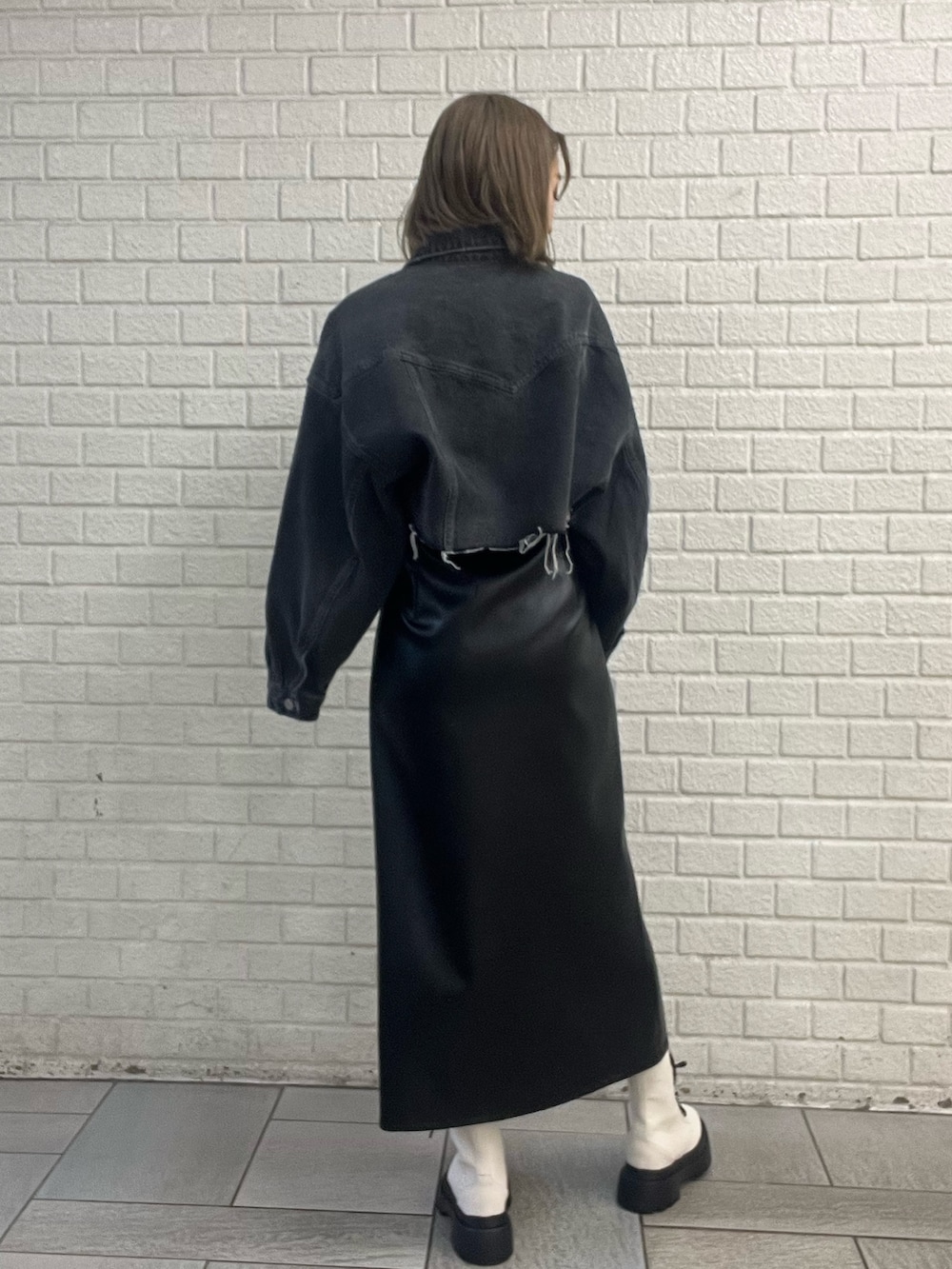 ブラック系のワンピース、ブルー系のデニムジャケット、ホワイト系のブーツを着用したレディースの冬コーディネートの7枚目の写真