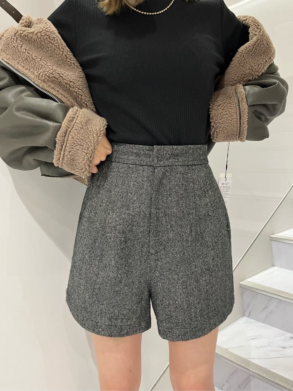 グリーン系のブルゾン、ブラック系のその他パンツ、ブラック系のハンドバッグを着用したレディースの秋コーディネートの6枚目の写真