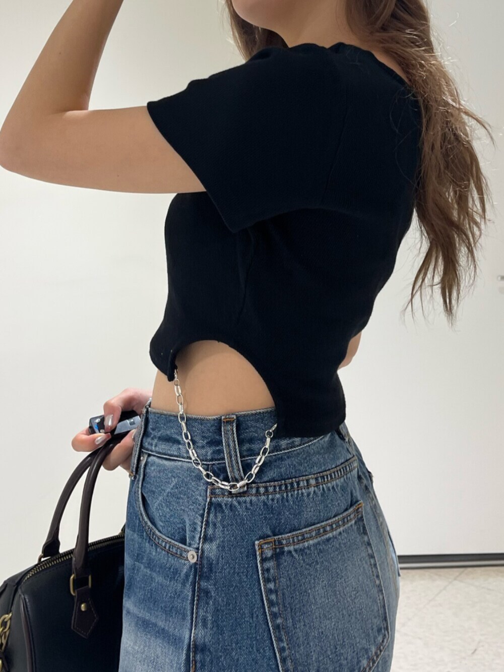 ブラック系のブーツ、ブルー系のデニムパンツ、その他のショルダーバッグを着用したレディースの春コーディネートの5枚目の写真