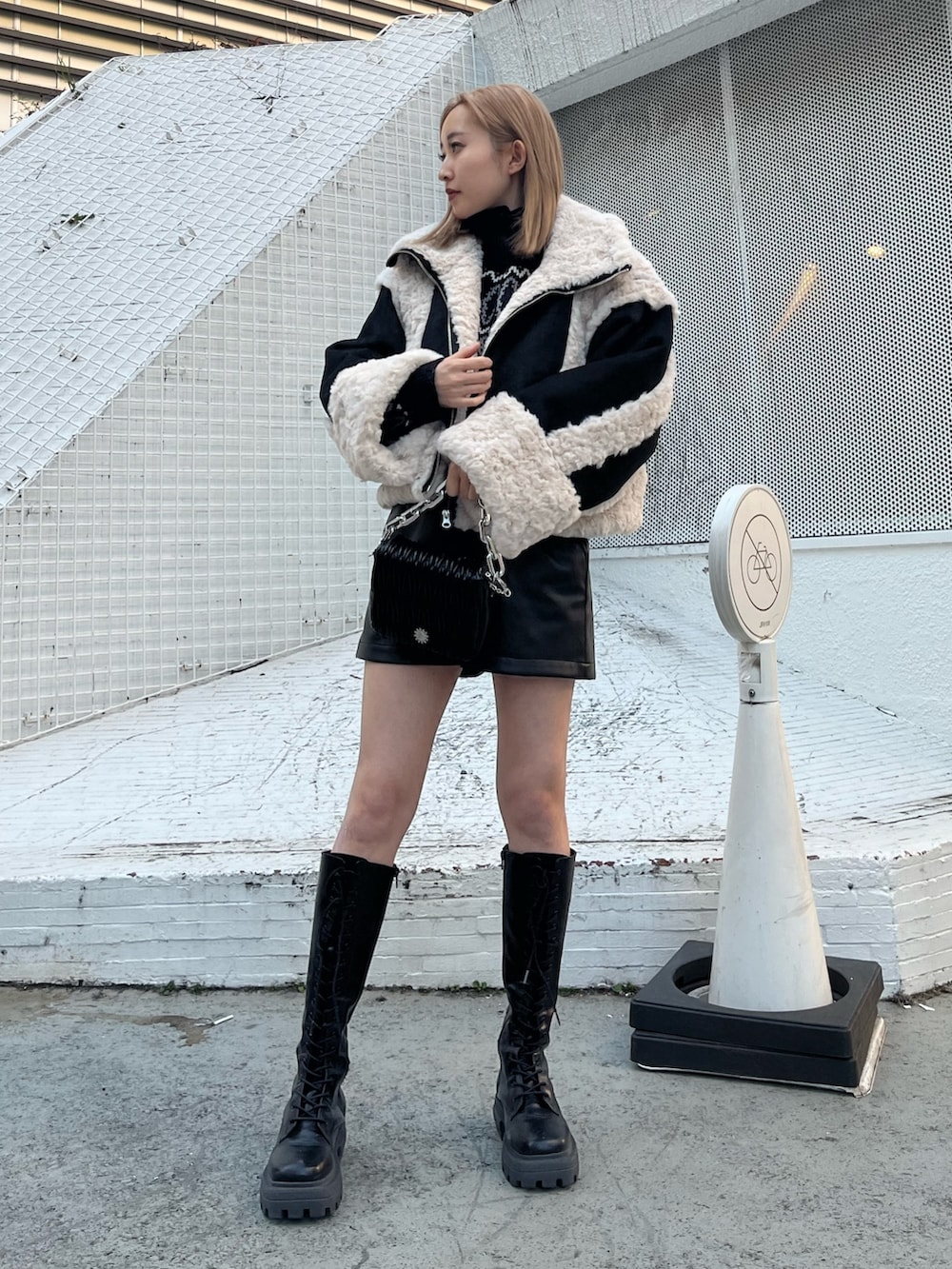 ブラック系のニット/セーター、ベージュ系のその他パンツ、ブラック系のブーツを着用したレディースの冬コーディネートの10枚目の写真