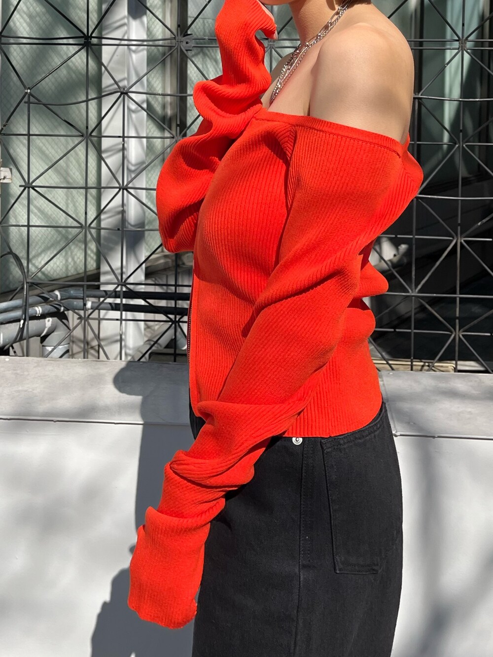 ブラック系のニット/セーター、ブラック系のデニムパンツを着用したレディースの春コーディネートの5枚目の写真