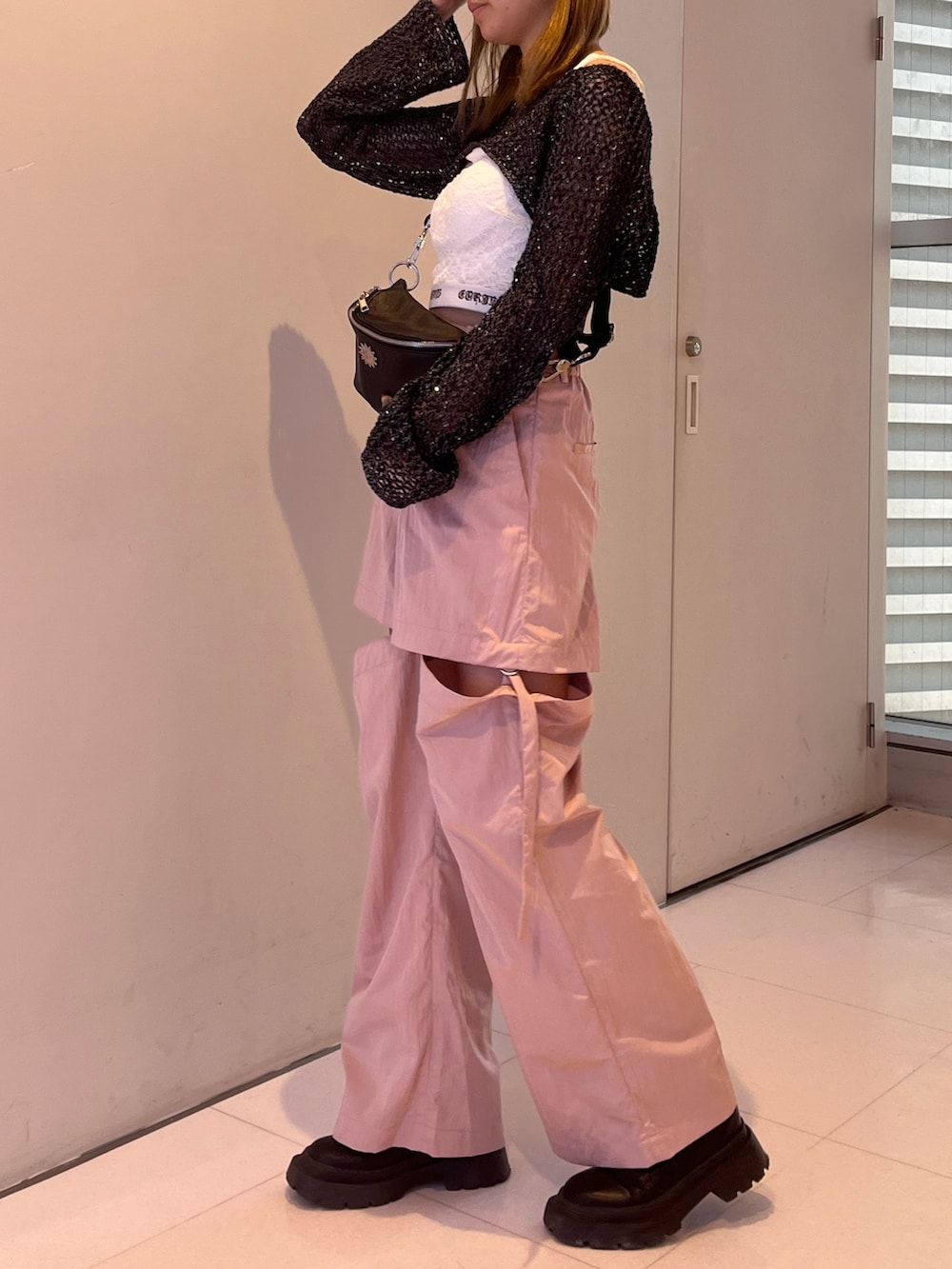 ピンク系のカーゴパンツ、ブラック系のキャミソール、ブラック系のニット/セーターを着用したレディースの春コーディネートの2枚目の写真