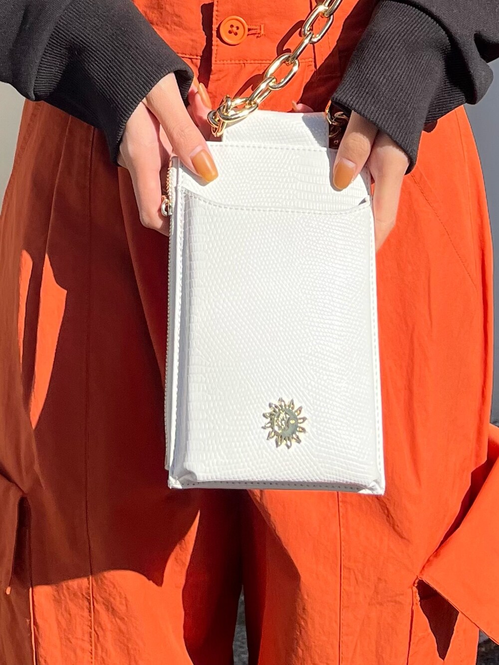 ブルー系のデニムパンツ、ホワイト系のショルダーバッグ、ピンク系のカーディガン/ボレロを着用したレディースの冬コーディネートの6枚目の写真