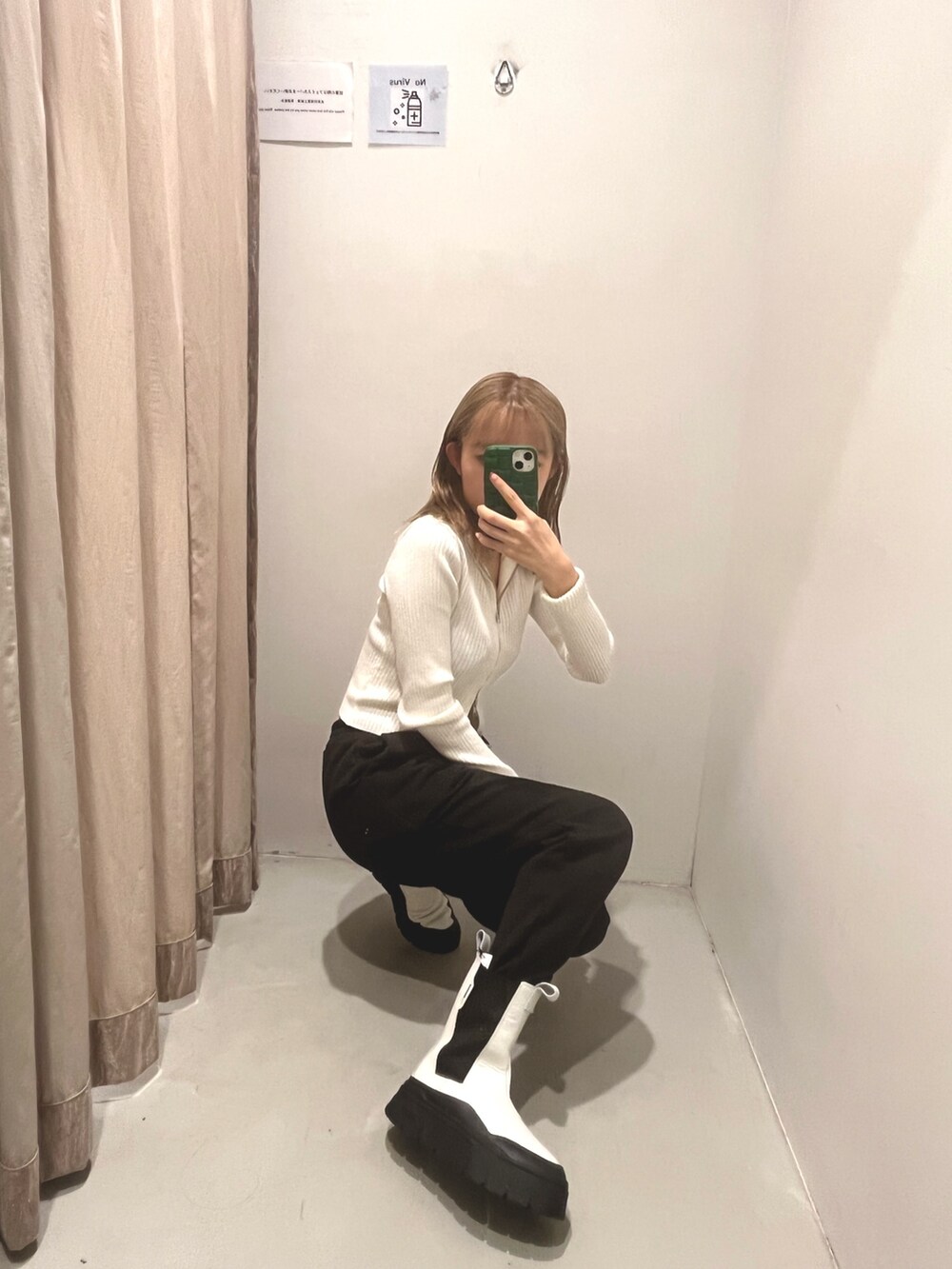 ブラック系のスウェットパンツ、ホワイト系のブーツ、ホワイト系のニット/セーターを着用したレディースの冬コーディネートの2枚目の写真
