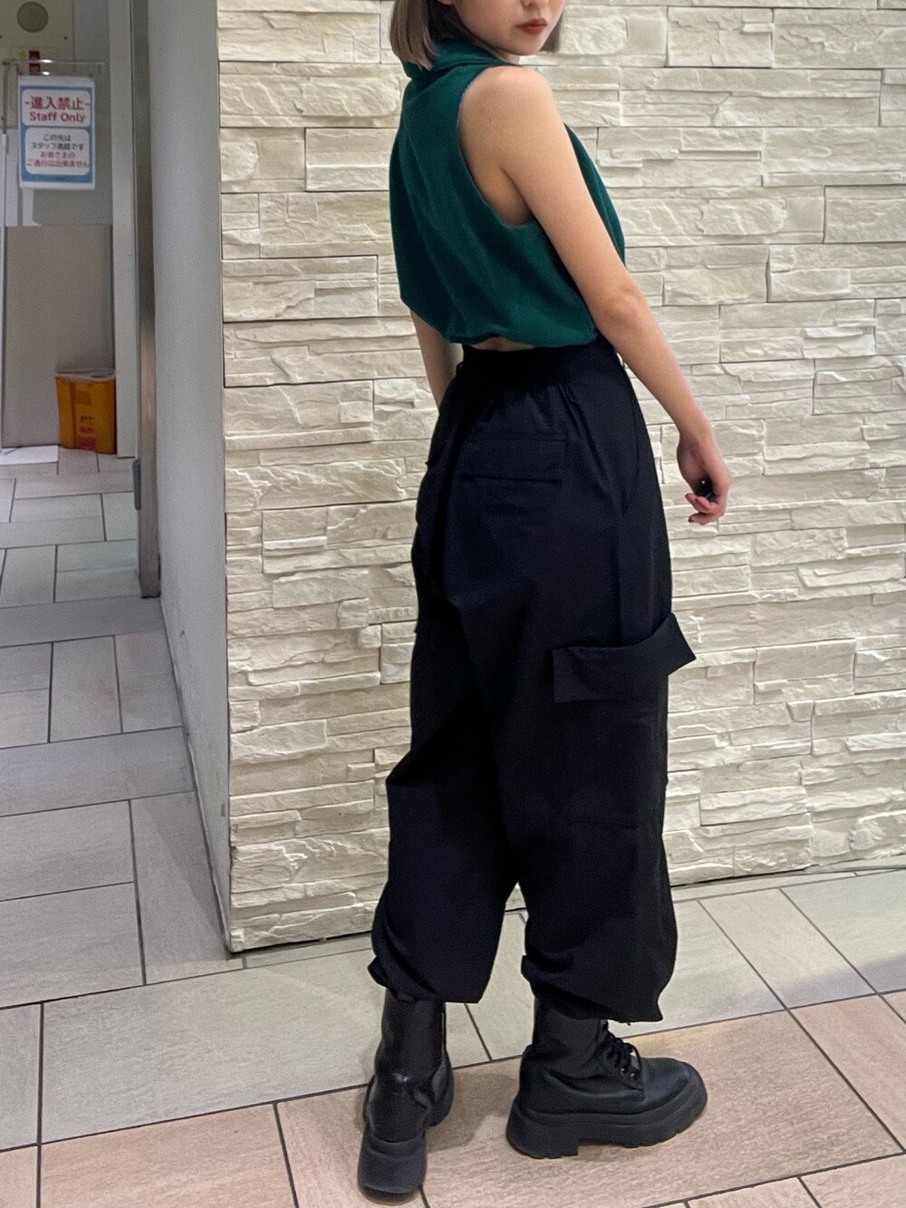 ブラック系のタンクトップ、パープル系のカーゴパンツ、ブラック系のブーツを着用したレディースの春コーディネートの5枚目の写真