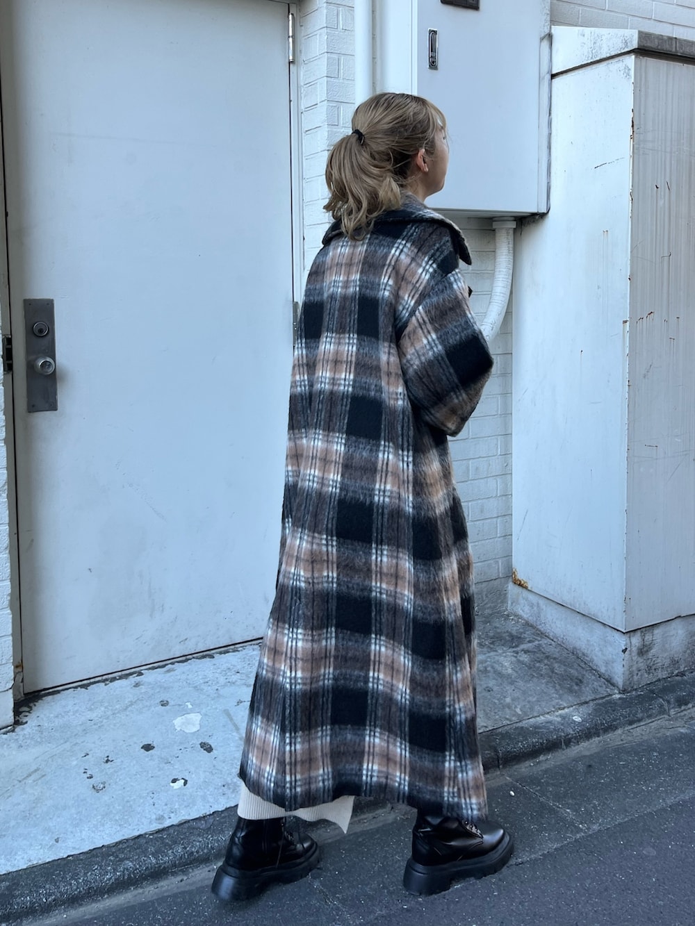 ホワイト系のワンピース、グリーン系のその他アウター、ブラック系のブーツを着用したレディースの冬コーディネートの4枚目の写真