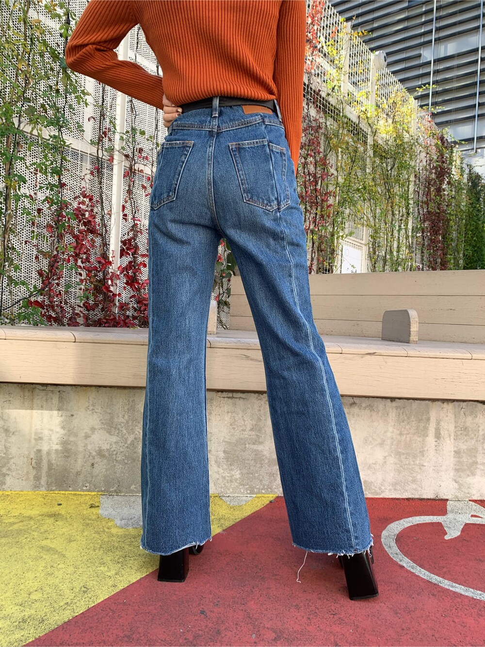 ブラック系のブーツ、ホワイト系のブルゾン、ブルー系のデニムパンツを着用したレディースの冬コーディネートの4枚目の写真