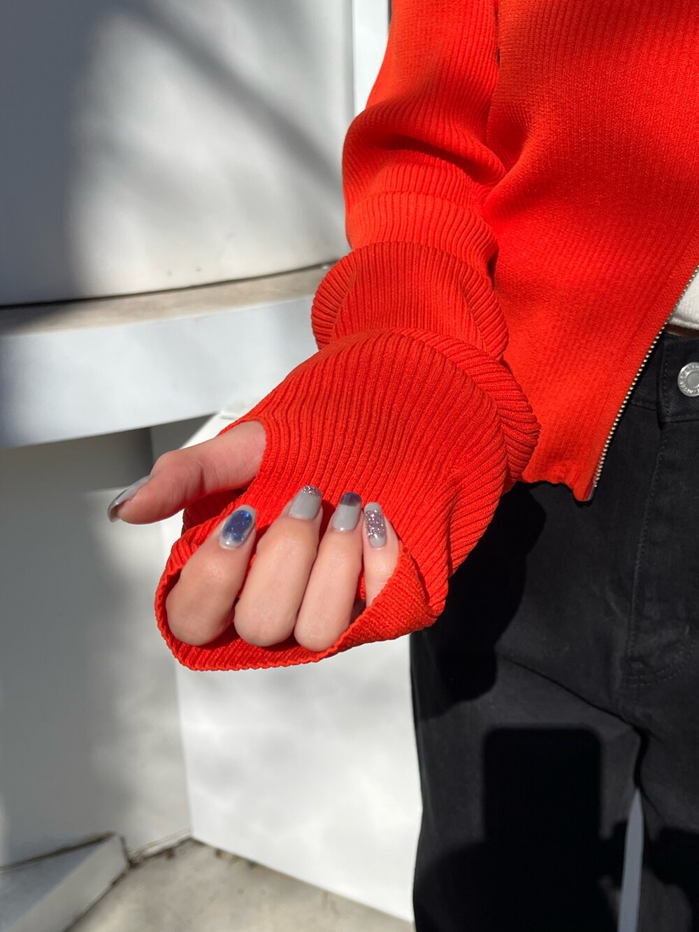 ブラック系のニット/セーター、ブラック系のデニムパンツを着用したレディースの春コーディネートの6枚目の写真