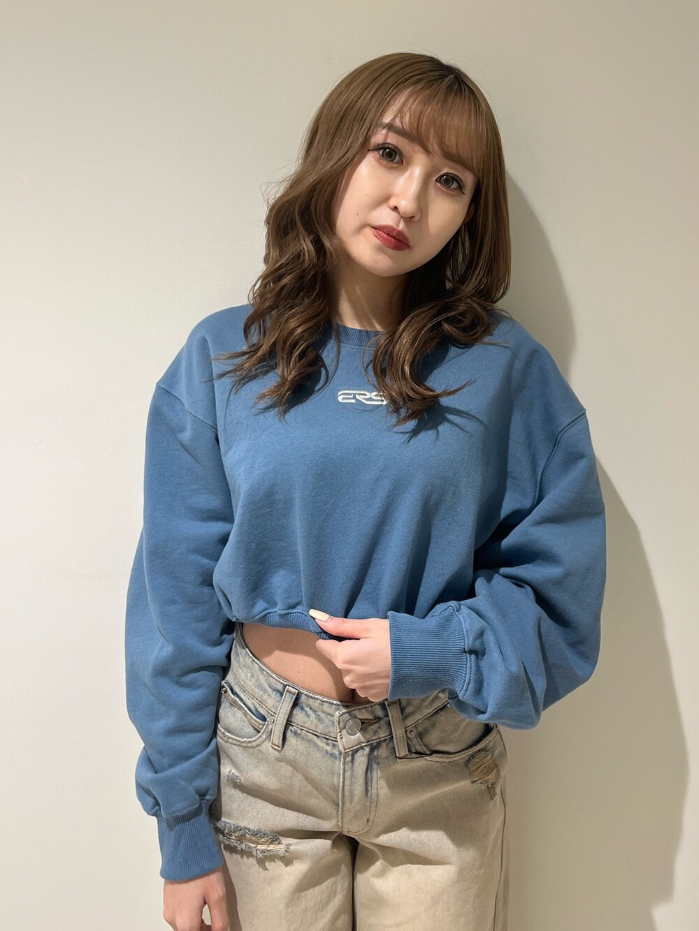 ブラック系のブーツ、ベージュ系のデニムパンツ、ブルー系のスウェットを着用したレディースの冬コーディネートの4枚目の写真