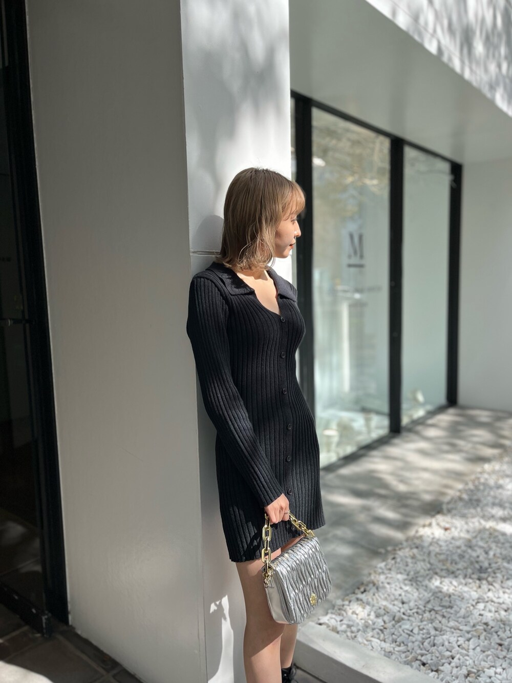 ブラック系のワンピース、シルバー系のショルダーバッグ、ホワイト系のブーツを着用したレディースの秋コーディネートの3枚目の写真