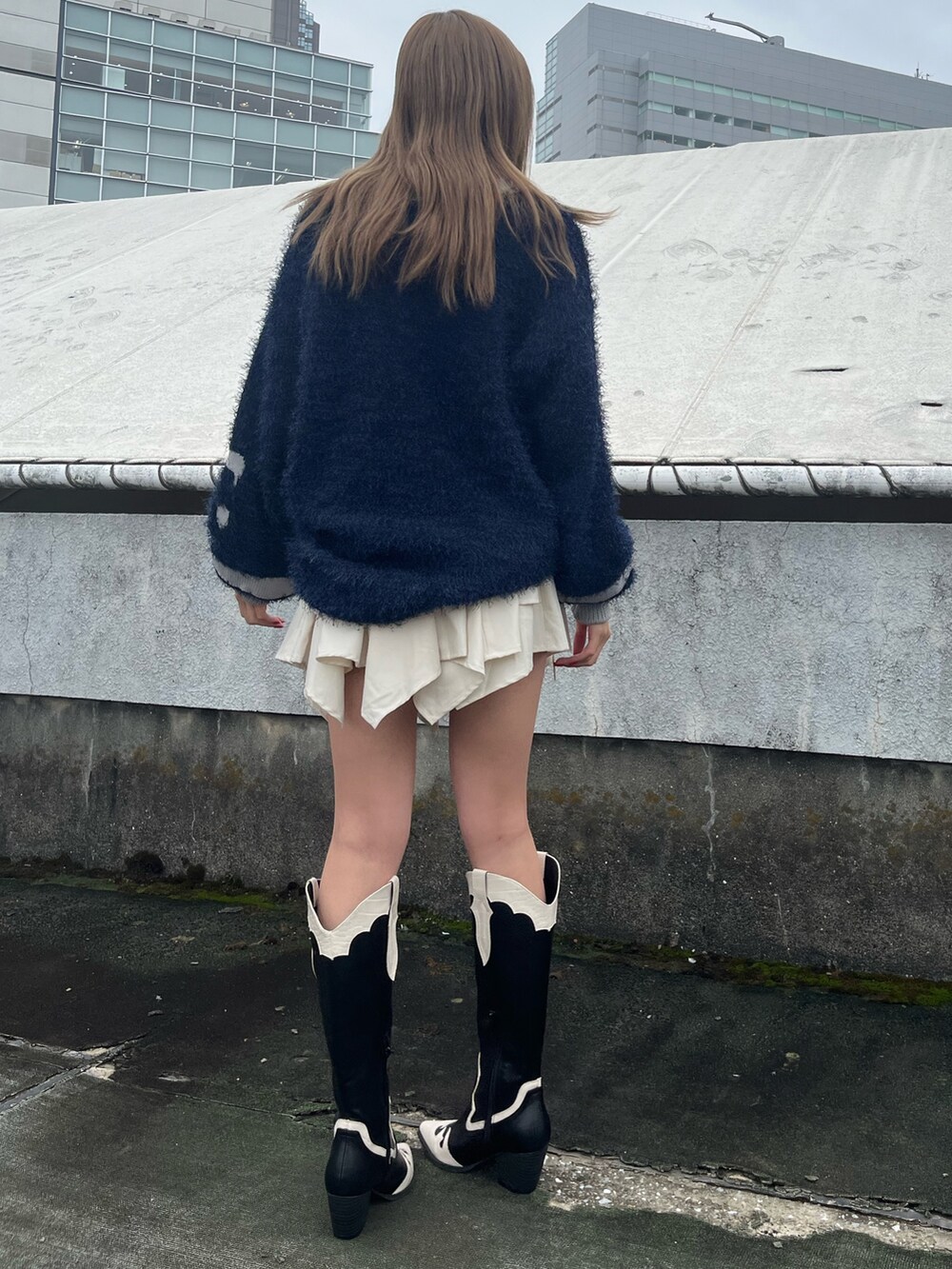 ホワイト系のスカート、ブラウン系のブーツ、ブルー系のニット/セーターを着用したレディースの秋コーディネートの3枚目の写真