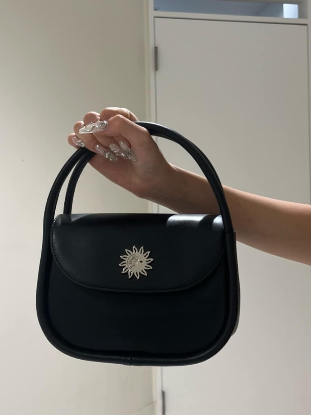 ブラック系のブーツ、ブルー系のシャツ/ブラウス、ブラック系のハンドバッグを着用したレディースの夏コーディネートの5枚目の写真