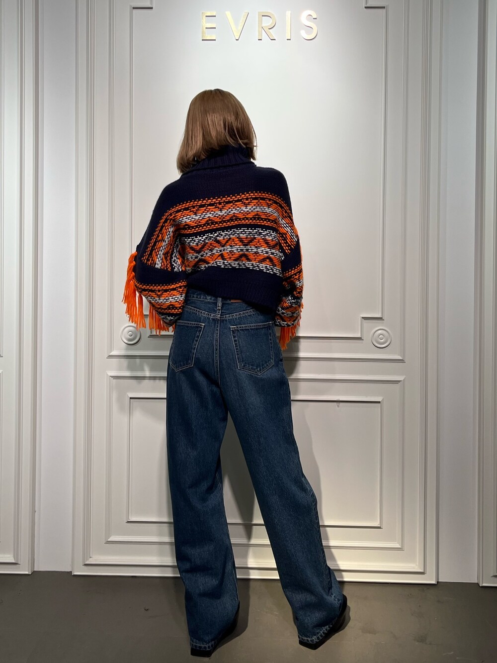 ブルー系のニット/セーター、ブラック系のブーツ、ブラック系のデニムパンツを着用したレディースの秋コーディネートの8枚目の写真