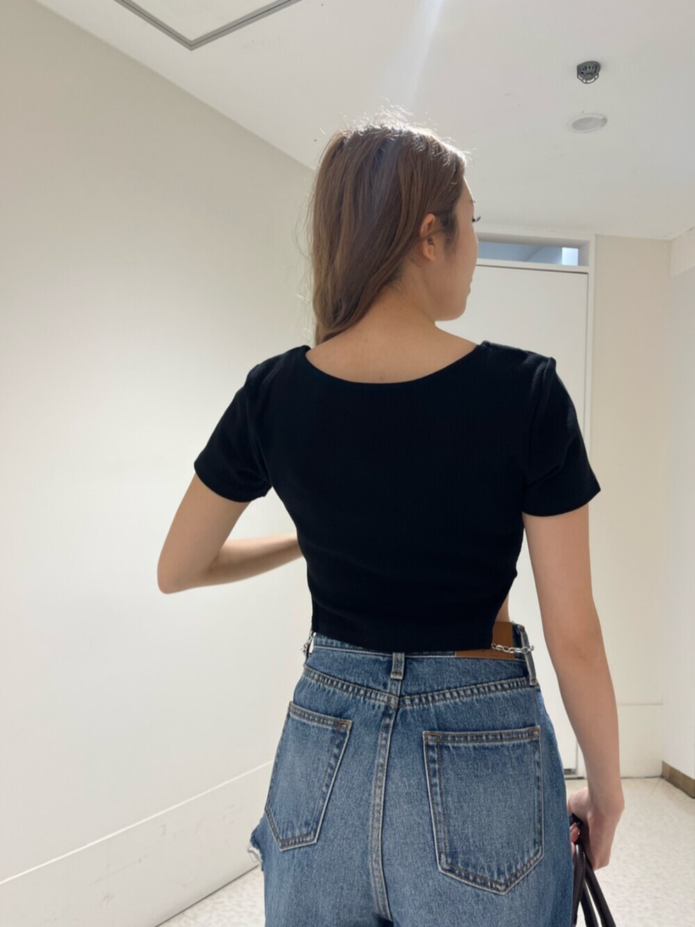 ブラック系のブーツ、ブルー系のデニムパンツ、その他のショルダーバッグを着用したレディースの春コーディネートの6枚目の写真