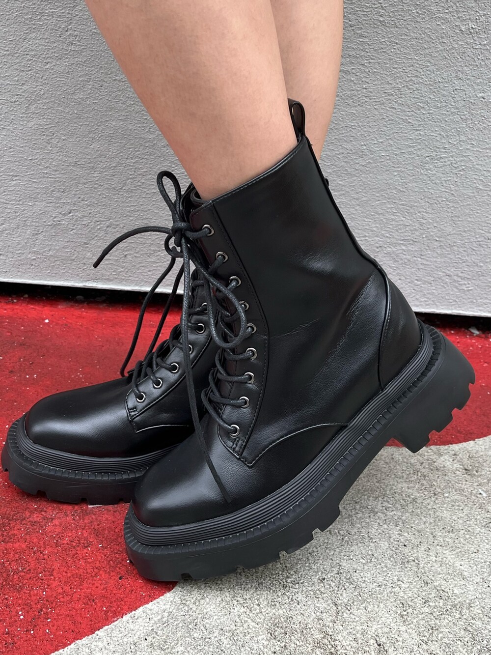 ブルー系のデニムパンツ、ブラウン系のハンドバッグ、ブラック系のブーツを着用したレディースの春コーディネートの7枚目の写真