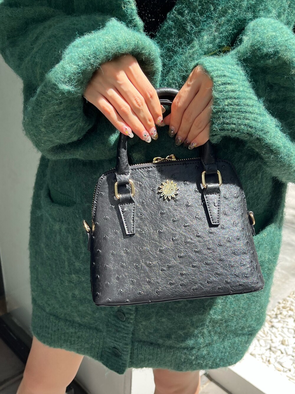 ブラック系のブーツ、ブラック系のショルダーバッグ、グリーン系のカーディガン/ボレロを着用したレディースの秋コーディネートの6枚目の写真