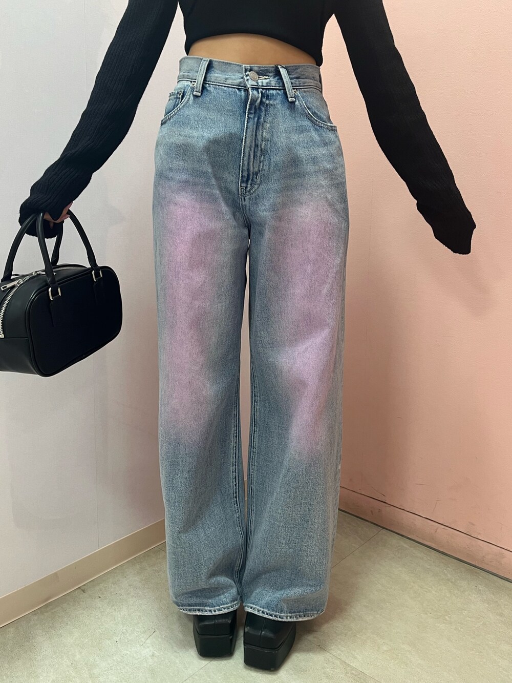 ブラック系のボストンバッグ、ブラック系のブーツ、イエロー系のニット/セーターを着用したレディースの春コーディネートの5枚目の写真