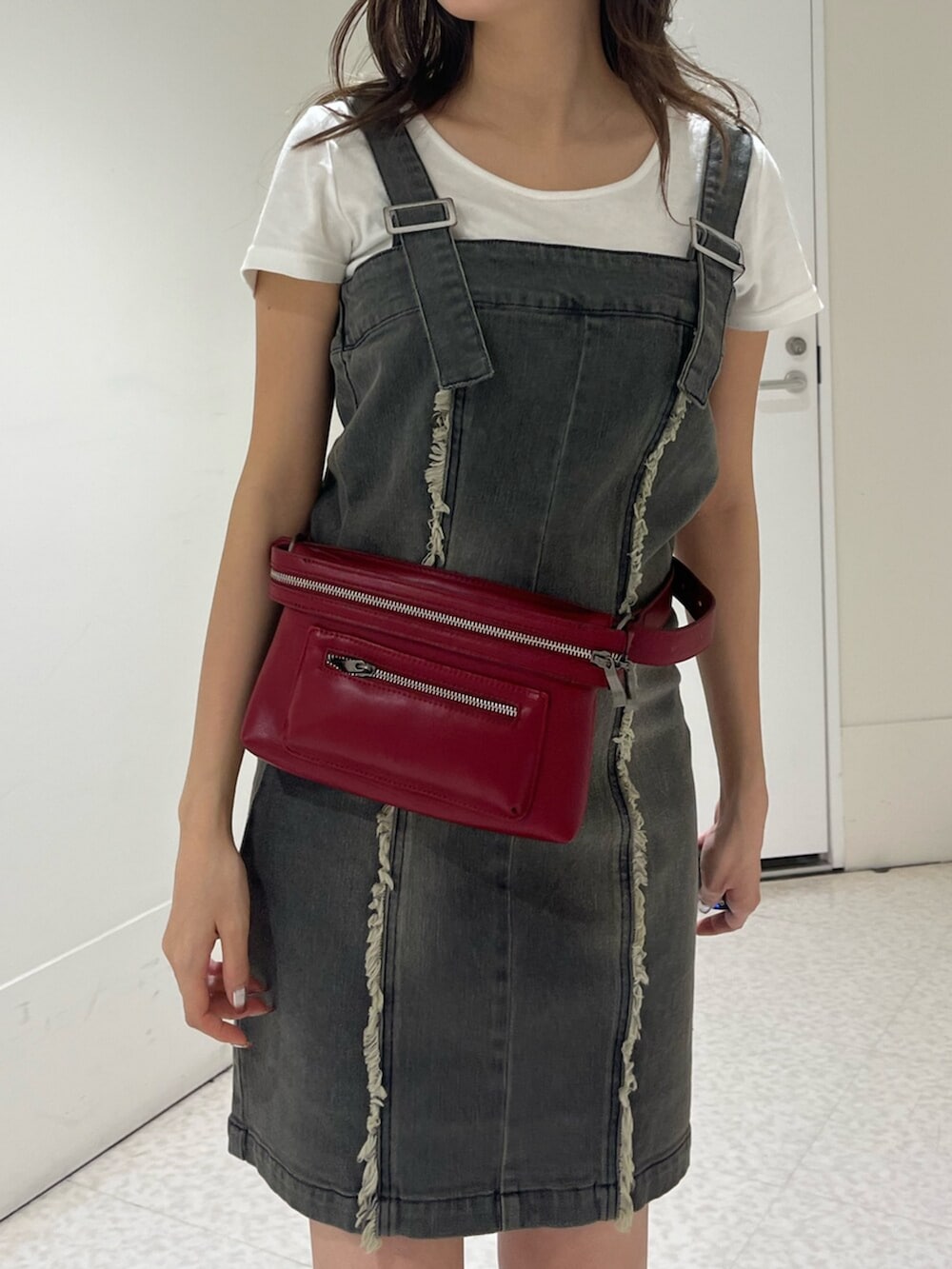 ブラック系のブーツ、ベージュ系のワンピース、レッド系のショルダーバッグを着用したレディースの夏コーディネートの5枚目の写真